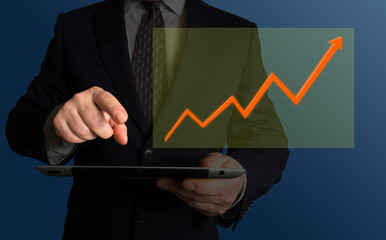 Increasing revenues, profit, quality or satisfaction rates. Businessman holding a tablet or a phone looking at a screen displaying a chart with steadily growing curve.