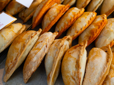 Fototapeta Closeup of baked snack empanada at market, popular spanish street food