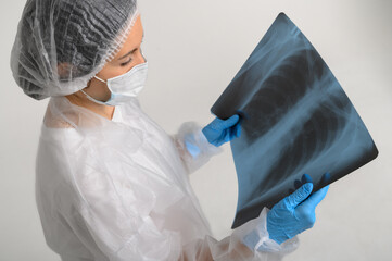 a nurse in a medical gown, mask and protective gloves