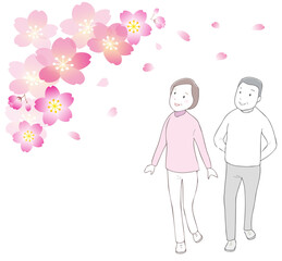 美しく咲いた桜を見上げながら散歩するシニア
