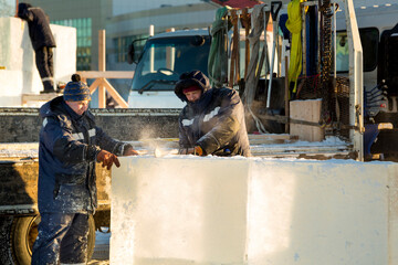 Worker cuts ice panel with gasoline saw