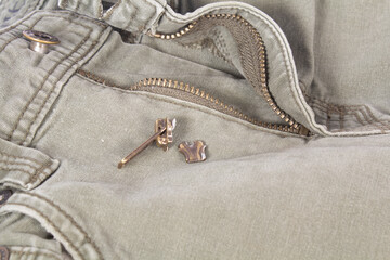 Broken Pants Zipper Slider with Green Jeans Isolated on White © Cloud Cap