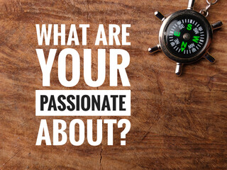 Top view compass with text WHAT ARE YOUR PASSIONATE ABOUT? on wooden background.