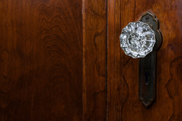 Detail of old wooden door with antique, glass, doorknob