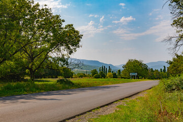 Fototapeta premium wide paved road towards the mountains goes