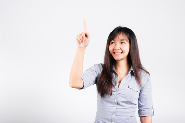 Woman standing her smile confidence with touching an imaginary screen with her finger isolated white background, Asian happy portrait beautiful young female pushing on button in studio shot