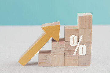 Wooden blocks with percentage sign and arrow up, financial growth, interest rate increase,...