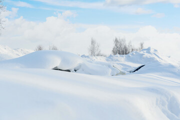 Cars in the parking lot littered with snow on the roof after a snowstorm in Russia.