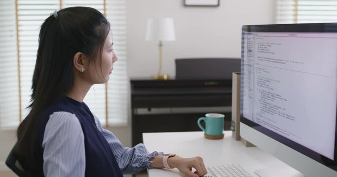 Asia young business woman sit busy at home office desk work code on desktop reskill upskill for job career remote self test IT deep tech ai design skill online html text for cyber security workforce.
