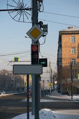 Road traffic light at the corner of an intersection in the city.