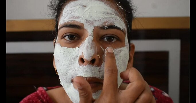 Indian Woman applying Neem face mask for pimple free skin