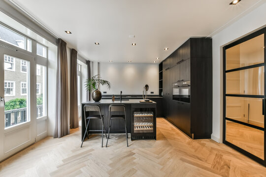 Modern kitchen with black furniture and wooden floor