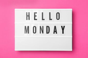 Light box with message Hello Monday on pink background, top view