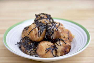 Takoyaki most popular delicious snack of japan topping with mayonnaise on a white plate. soft selected focus. or octopus balls Japanese food. Close up