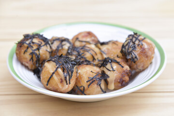 Takoyaki most popular delicious snack of japan topping with mayonnaise on a white plate. soft selected focus. or octopus balls Japanese food. Close up