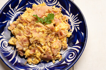 Scrambled eggs with ham for breakfast