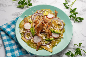 Green chilaquiles with pork meat and cheese. Mexican food