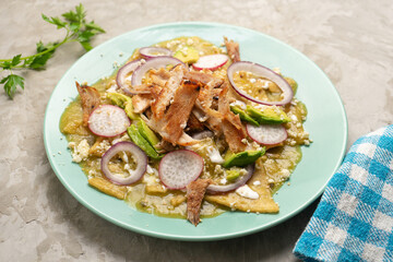 Green chilaquiles with pork meat and cheese. Mexican food