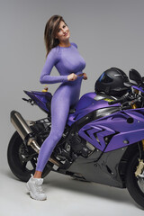 Fototapeta na wymiar Shot of brown haired smiling woman posing on motorcycle