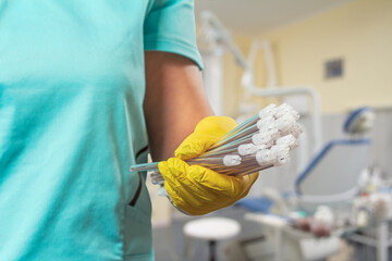 Dentist's hand in glove with saliva ejectors.