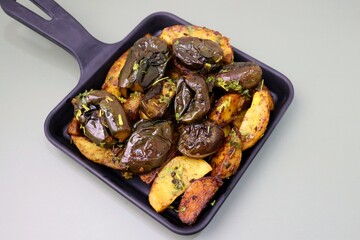 Baingan masala. Indian Potato and aubergine curry. Homemade Indian spicy eggplant and potato curry, served in a white plate. Copy space.