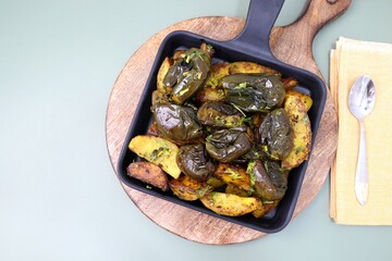 Baingan masala. Indian Potato and aubergine curry. Homemade Indian spicy eggplant and potato curry, served in a white plate. Copy space.