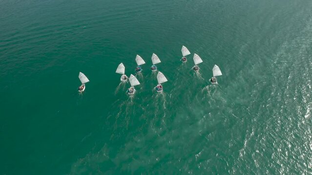 Topdown view follow Optimist boats navigate on river, Sailing boats for kids learning
