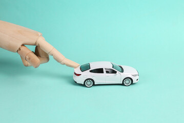 Hand pushing toy car model on blue background