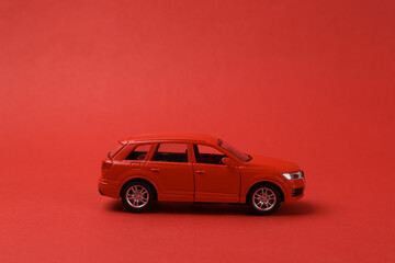 Fototapeta na wymiar Mini model red toy car on red background