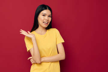 Obraz premium woman with Asian appearance in a yellow t-shirt gesturing with his hands fun isolated background unaltered