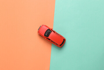 Model toy car on a blue-pink background. Top view. Flat lay