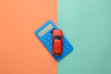 Toy car model with a calculator on pink, blue background. Cost calculation, car purchase, fuel...