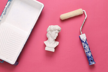 Painting roller and bust of David on a pink background. Restoration symbol