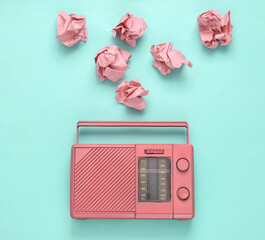 Retro radio with crumpled paper balls on blue background