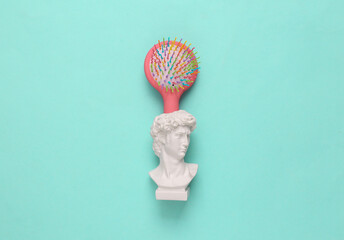 Head of David with colored hairbrush on a light blue background. Top view