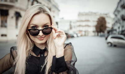 Portrait of fashionable stylish blonde woman in sunglasses in european city