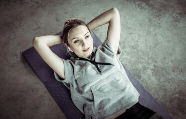 Urban style training abdominal muscles of a young fit woman lying on a mat. Healthy lifestyle