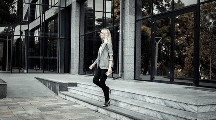 Confident business woman going out from business office