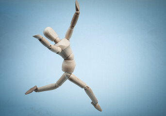 Cheerful wooden puppet jumping on blue background