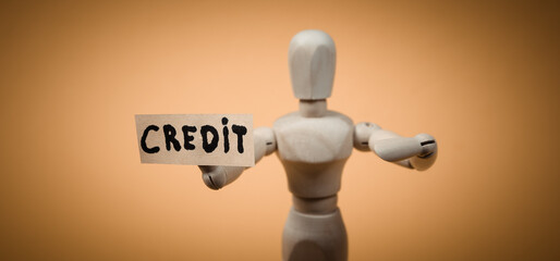 Text credit with wooden puppet figure on yellow background