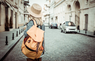Nice beautiful millennial tourist woman with backpack in jeans jacket  discover European city at...