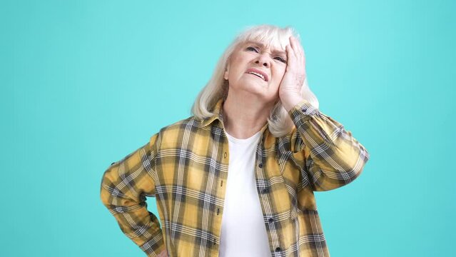 Granny feel unhealthy suffer severe head ache isolated cyan color background
