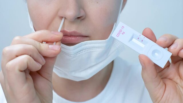 Girl making swab from the nose close-up, concept of home test for coronavirus.