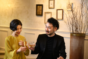 A man and a woman toasting at a bar.