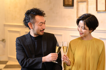 A man and a woman toasting at a bar.