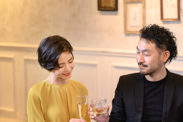 バーで乾杯をする男女 上にコピースペースあり