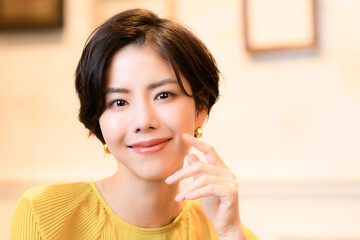 カメラ目線で顎に手を添える美しい女性　コピースペースあり