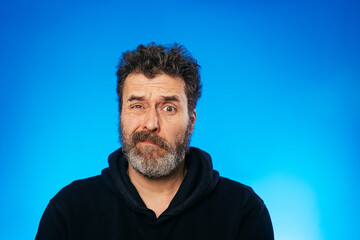 Skeptical old man emotions portraits on blue background