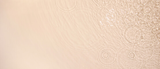 Abstract summer banner background Transparent beige clear water surface texture with ripples and...