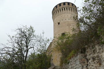 the fortress of Brisighella with mighty brick walls, two towers and the patrol walkway stands on a hill that dominates the village